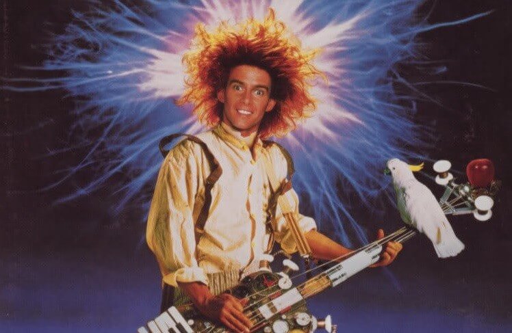 Einstein from movie Young Einstein the playing a guitar with a bird sitting on the guitar neck, while his wild hair seems electrified.